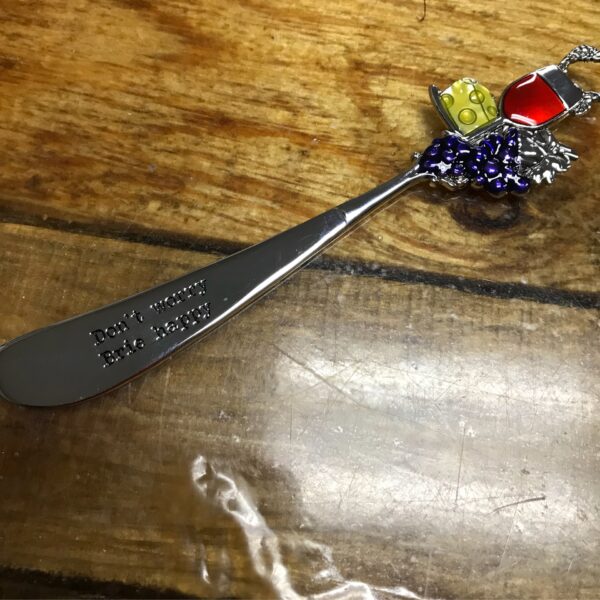 A spoon with a little red and blue object on it